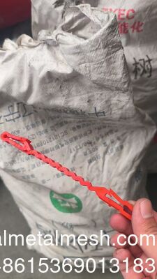 Красные пластиковые поддерживающие клипсы, которые устанавливаются между спиралью из колючей проволоки и проволокой